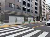 ACPレジデンス中野新橋 横断歩道から見たモダンな建物の低層部分と街並み