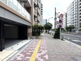 ACPレジデンス浅草 明るい日中の共用通路と駐車場入口の様子