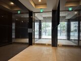 ACPレジデンス浅草 開放的なガラス張りのエントランスホール、落ち着いた木調タイル