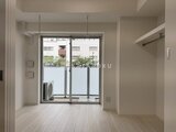 ACPレジデンス浅草 明るい床材の洋室とバルコニーへ続く大きな窓からの採光感