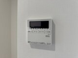 ACPレジデンス浅草 白いタイル壁に取り付けられたガス給湯器リモコン