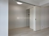 ACPレジデンス浅草 明るい照明と落ち着いた色調の洋室と奥のクローゼット