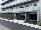 ジェノヴィア北千住 駐車場と共用エントランスを備えたモダンな建物外観