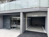 ジェノヴィア北千住 モダンな外観の建物1階にあるエントランスと駐車場入口の様子