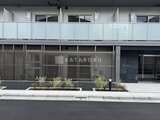 ジェノヴィア北千住 前面道路から見たモダンなファサードと植栽が配置されたエントラ