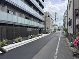 ジェノヴィア北千住 前面道路から見たモダンな建物外観と周辺街並み