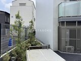 ジェノヴィア北千住 植栽を配置した落ち着いた印象の敷地と建物外観