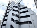 ジェノヴィア北千住 白基調のモダンな外観、バルコニーが連なる建物の角からの見上げ