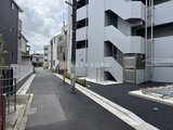 ジェノヴィア北千住 モダンな外観の建物と街並みが広がるアプローチの様子