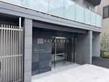 ジェノヴィア北千住 モダンな石貼りの壁とガラス扉を備えたエントランス