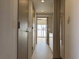 ジェノヴィア北千住 明るい採光が入るすっきりした廊下と収納ドアが並ぶ空間