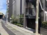 コンシェリア町屋 黒い格子戸と2階バルコニーを備えた落ち着いた印象の建物外観