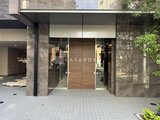 コンシェリア町屋 モダンな木目調ドアとガラス張りの落ち着いた印象のエントランス