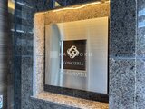 コンシェリア町屋 グレー調の石貼り壁に埋め込まれたモダンなエントランス表札