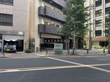 コンシェリア町屋 前面道路から見たエントランスと駐車場を備えた建物外観