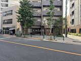 コンシェリア町屋 前面道路から見た建物外観と緑を配した開放的なエントランス