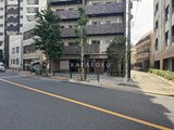 コンシェリア町屋 前面道路から見た建物外観と緑に囲まれた落ち着いたエントランス