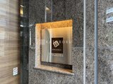 コンシェリア町屋 花崗岩張りの壁にスタイリッシュなロゴプレートが設置されたエン