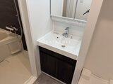 コンシェリア町屋 白い洗面ボウルと黒い収納が調和した洗面台