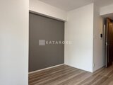 コンシェリア町屋 グレーのアクセントウォール付きの落ち着いた寝室スペース
