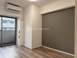コンシェリア町屋 明るい窓からの採光と落ち着いた色合いの1Kリビング