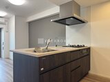 コンシェリア町屋 石調のキッチンパネルが落ち着いた印象のアイランドキッチン