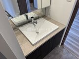 コンシェリア町屋 白い埋め込み型シンクと鏡付きの洗面台