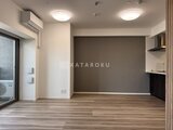 コンシェリア町屋 落ち着いた色合いの壁とフローリングのリビングダイニング空間