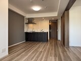 コンシェリア町屋 黒いキッチンカウンター付きの開放的なリビングダイニング空間