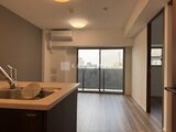 コンシェリア町屋 開放感のあるシステムキッチンとリビングダイニングを眺めた室内
