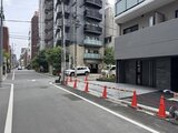 エスレジデンス入谷アレシア 前面道路から見た建物エントランスと駐車場の様子