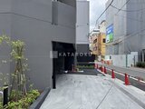 エスレジデンス入谷アレシア モダンな外観の建物エントランスと駐車場入口の様子