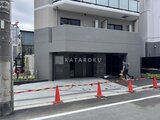 エスレジデンス入谷アレシア 黒いタイル張りのガレージと開放的なエントランス空間の建物外観