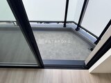 エスレジデンス入谷アレシア 黒いフレームの大きな窓から明るい光が差し込むバルコニー