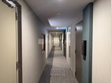 パークアクシス品川シーサイド 落ち着いた色合いの廊下に複数の住戸ドアが並ぶ共用通路