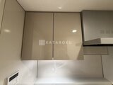 パークアクシス品川シーサイド 鏡面扉の吊り戸棚と作業スペースを備えたキッチン