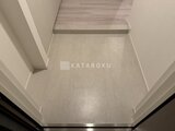 パークアクシス品川シーサイド 明るい色合いのフローリングと上がり框のある玄関ホール
