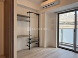 パークアクシス品川シーサイド 壁付けの棚とハンガーラック、エアコンのある居室