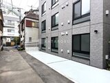 Aglaia 千石 Deux 白タイル張りの外壁が印象的な建物の前面道路側の様子