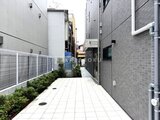 Aglaia 千石 Deux 白いタイル舗装の落ち着いた印象のアプローチ通路