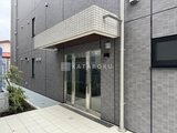 Aglaia 千石 Deux モダンなタイル張りの外壁とガラス張りエントランスの建物正面
