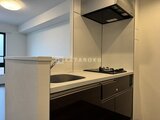 Aglaia 千石 Deux 白を基調とした明るいキッチンで、シンク、ガスコンロ、レンジフ