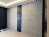 グランカーサ住吉2 明るい照明と落ち着いた色合いのタイル張りエレベーターホール