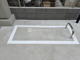 グランカーサ住吉3 白枠で囲まれたコンクリート床の屋外共用部スペース