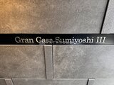 グランカーサ住吉3 建物名が刻まれたモダンな外壁タイル張りの仕上げ