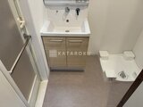 グランカーサ住吉3 木目調の洗面台と便器がコンパクトにまとまった洗面トイレ空間