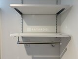 グランカーサ住吉3 白を基調とした収納スペースに物干しバー付きの棚が備わった洗濯