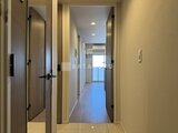 アーバネックス錦糸公園3 明るい照明に照らされた廊下と複数の居室ドアの様子