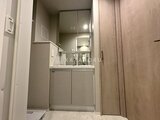 ビューテラス茗荷谷 洗面台と鏡が備わった、落ち着いた色合いの洗面脱衣室