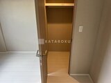 ビューテラス茗荷谷 木製フレームの開き戸で、奥に棚とハンガーパイプを備えた収納ス